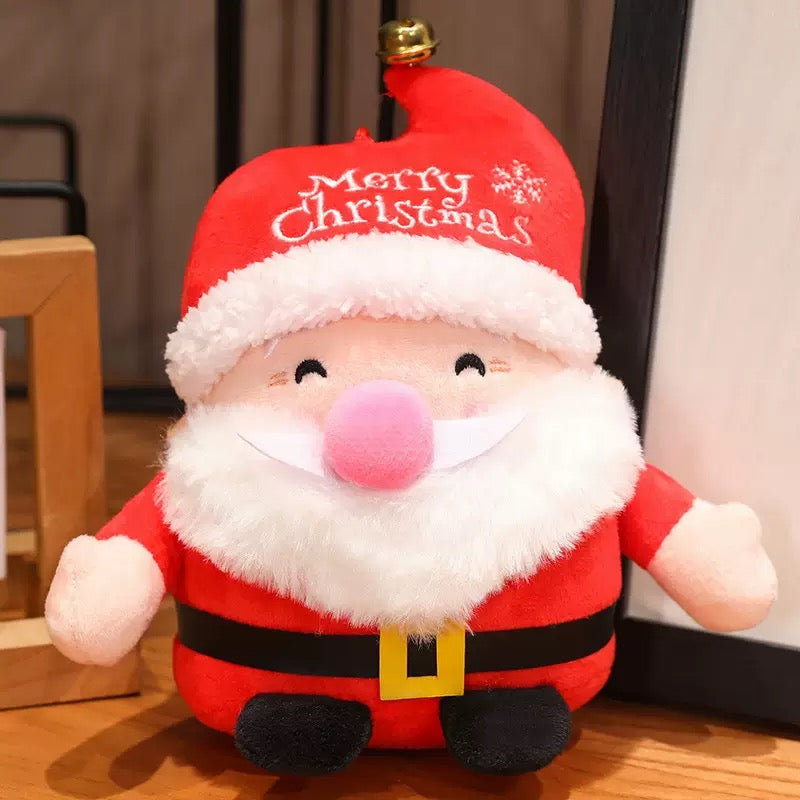 Plush Santa Claus toy with 'Merry Christmas' hat on a wooden floor.